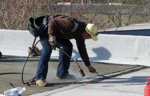 Torching - Applying a direct flame to a membrane for the purpose of melting the roofing material so that it will adhere to the substrate and or similar material.